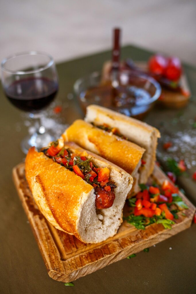 Mouth-watering Argentine choripán with chimichurri sauce and a glass of red wine.