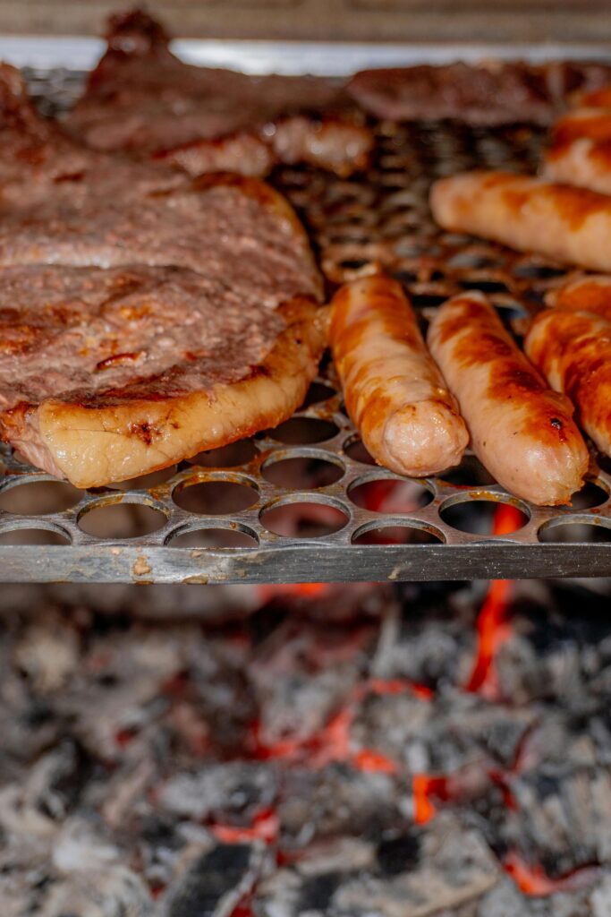 Delicious sausages and meats grilling over hot charcoal, perfect for a summer barbecue.